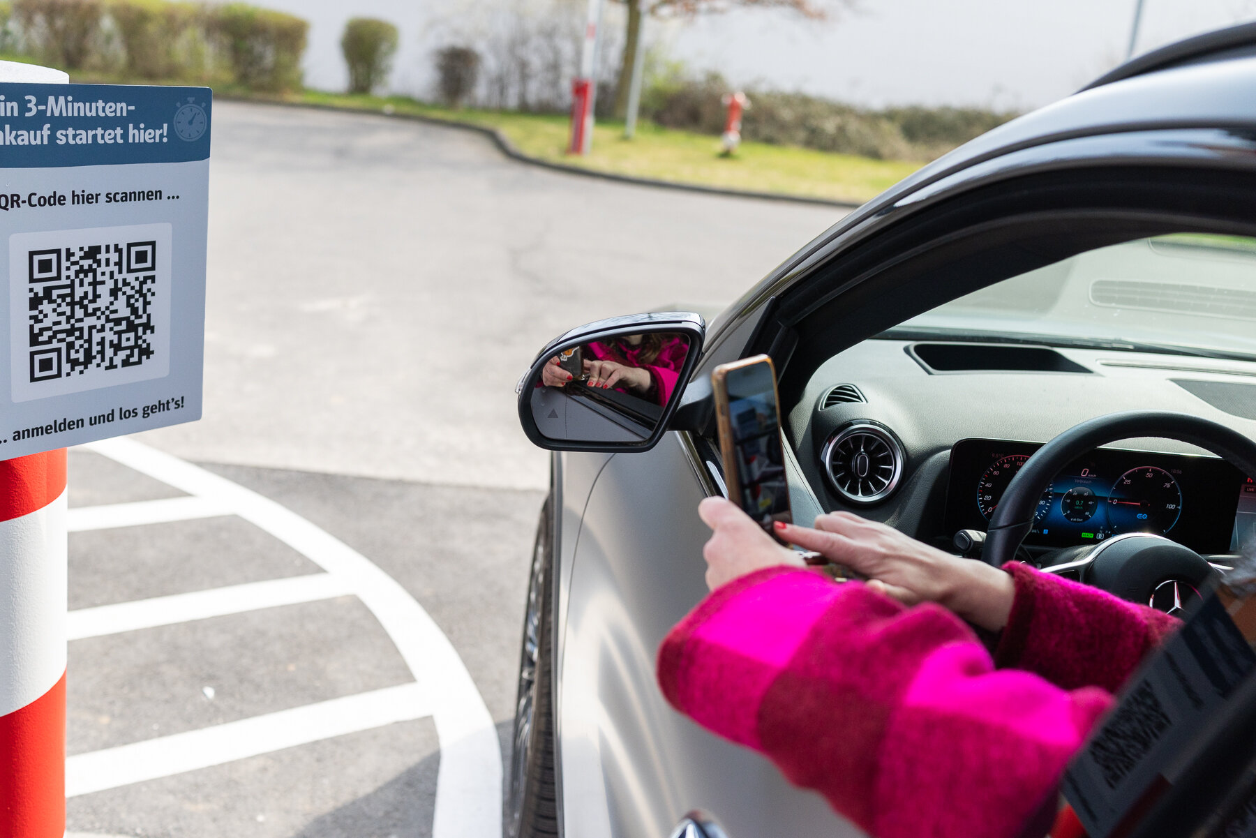 Kundin meldet sich im REWE Abholservice Drive&Go per QR-Code an