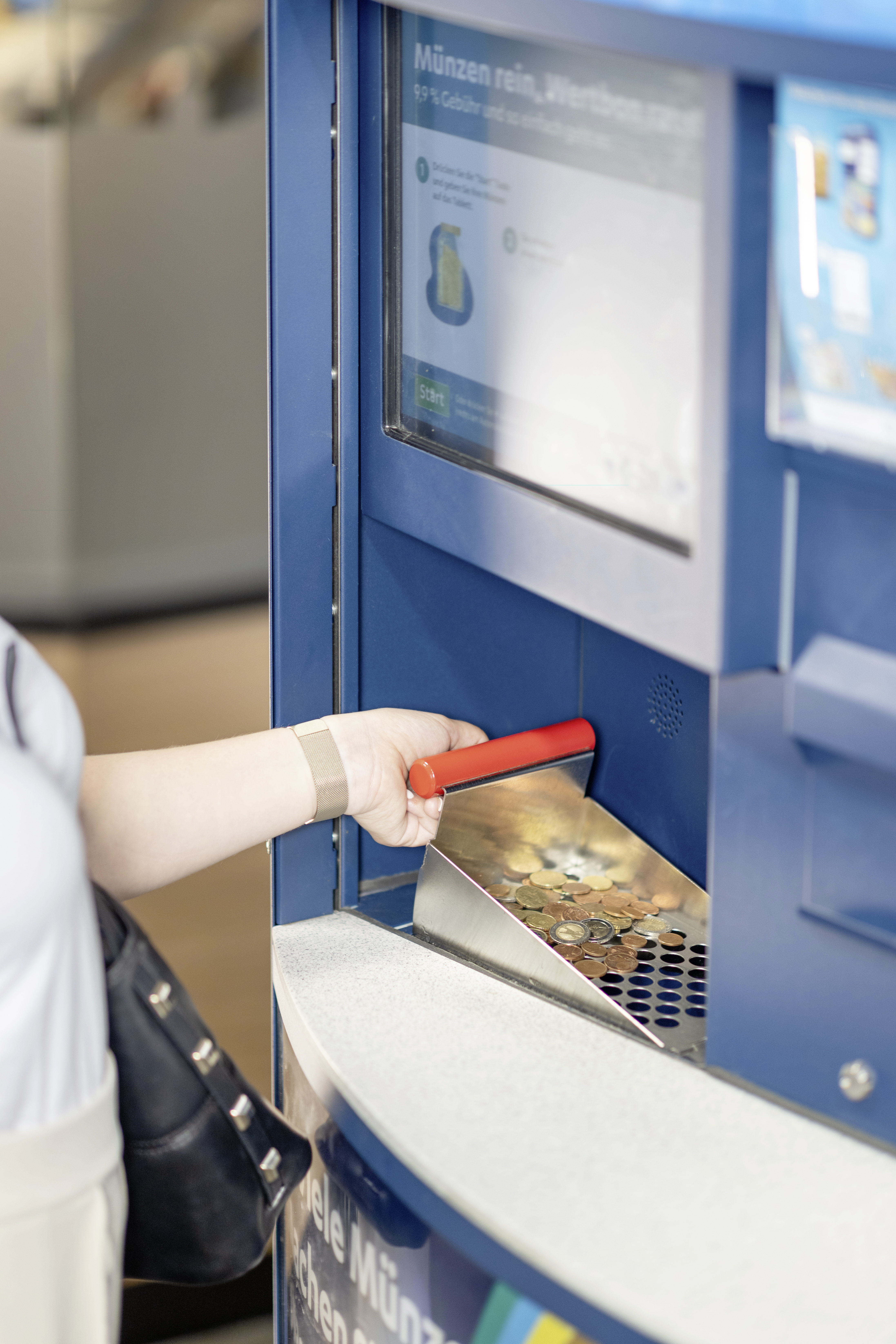 Kleingeld wird im Coinstar-Automat getauscht | © REWE