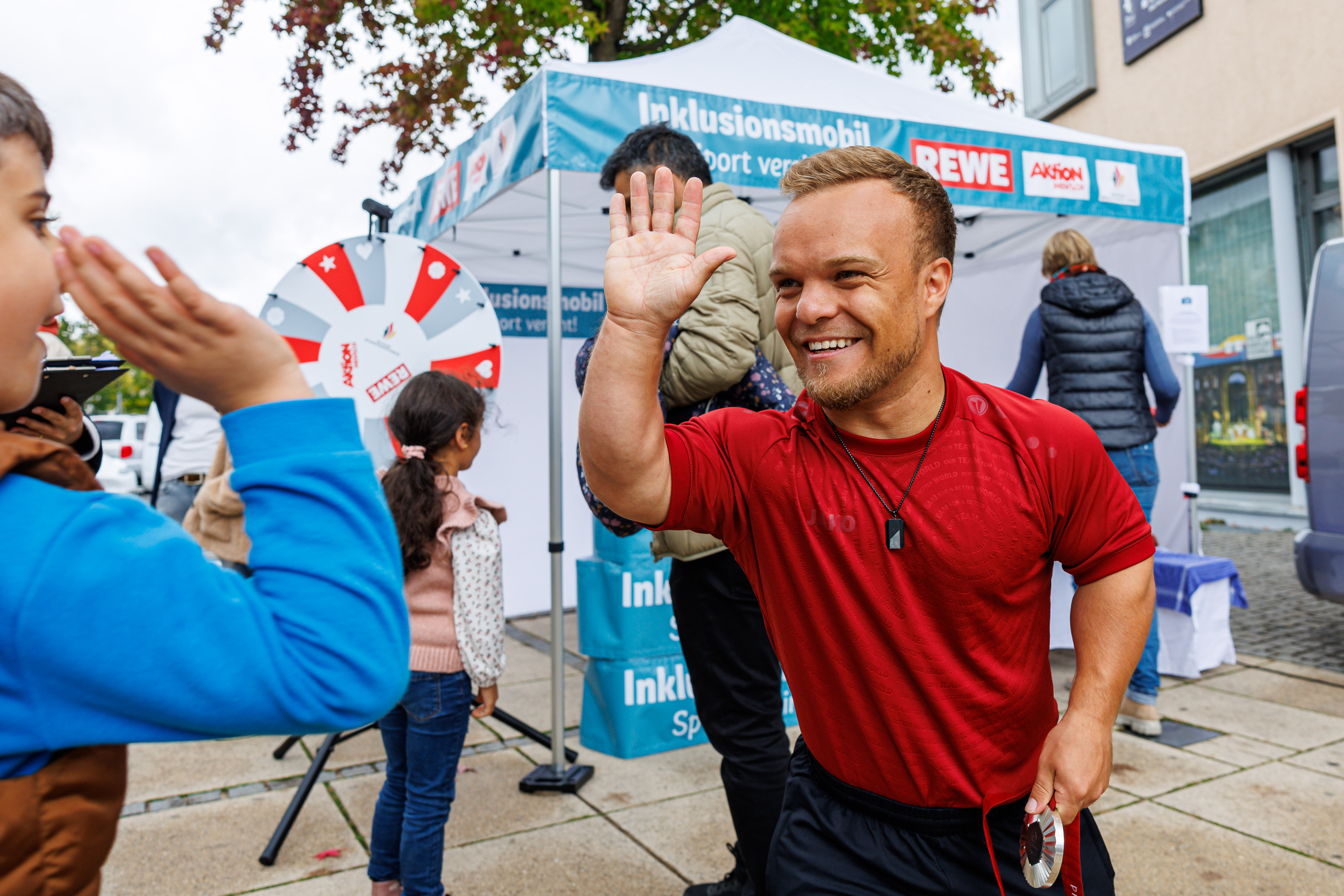 Niko Kappel gibt ein High Five beim Inklusionsmobil