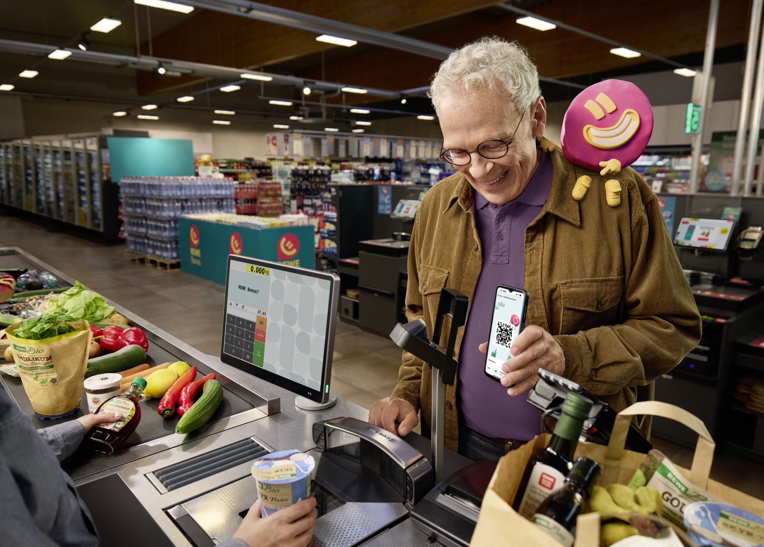 Älterer Mann scannt REWE App an der Kasse