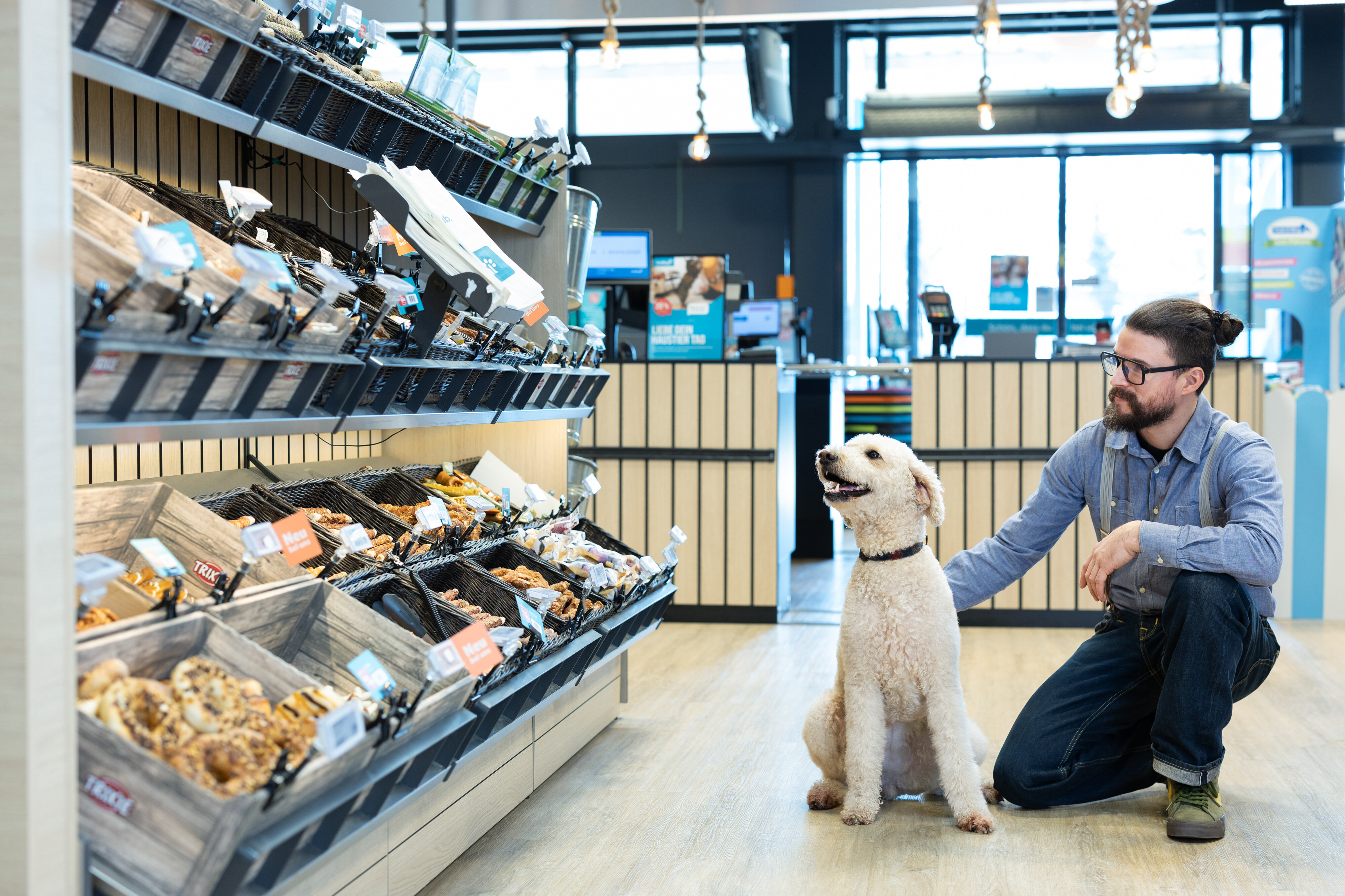 Pudel steht mit Besitzer vor Hundesnackbar im ZooRoyal-Markt