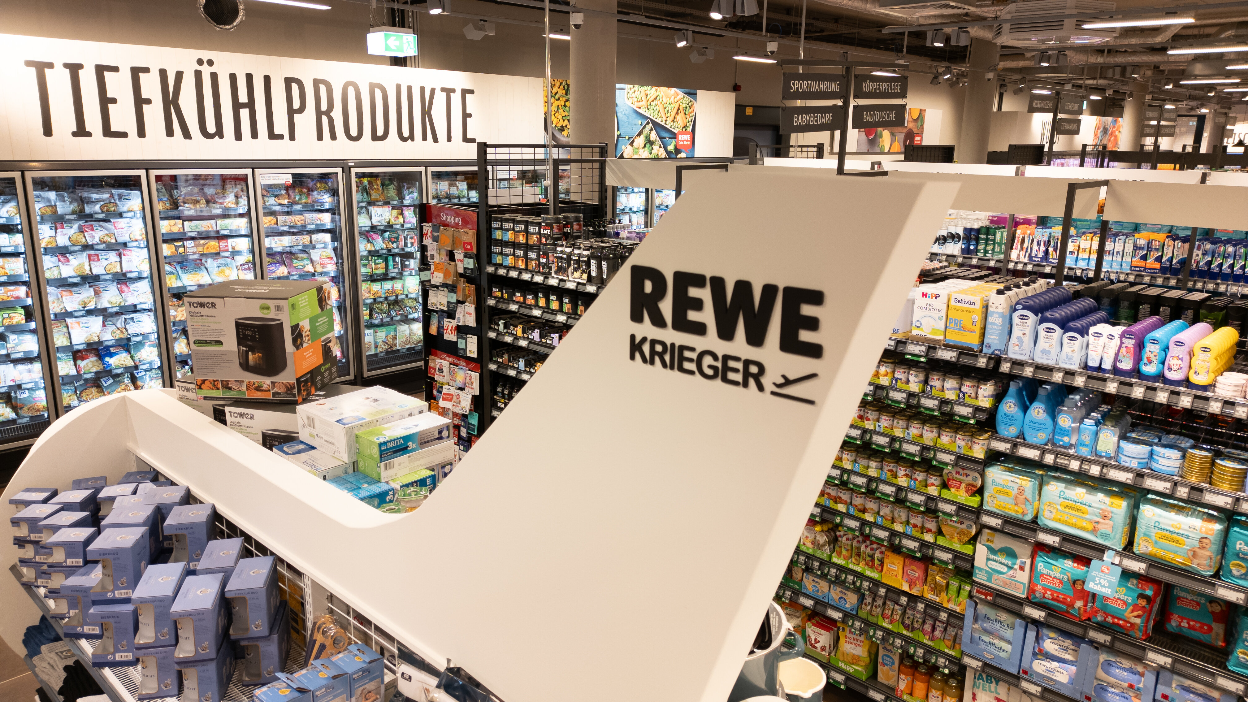 Regal in Flugzeugform mit Schriftzug REWE Krieger.