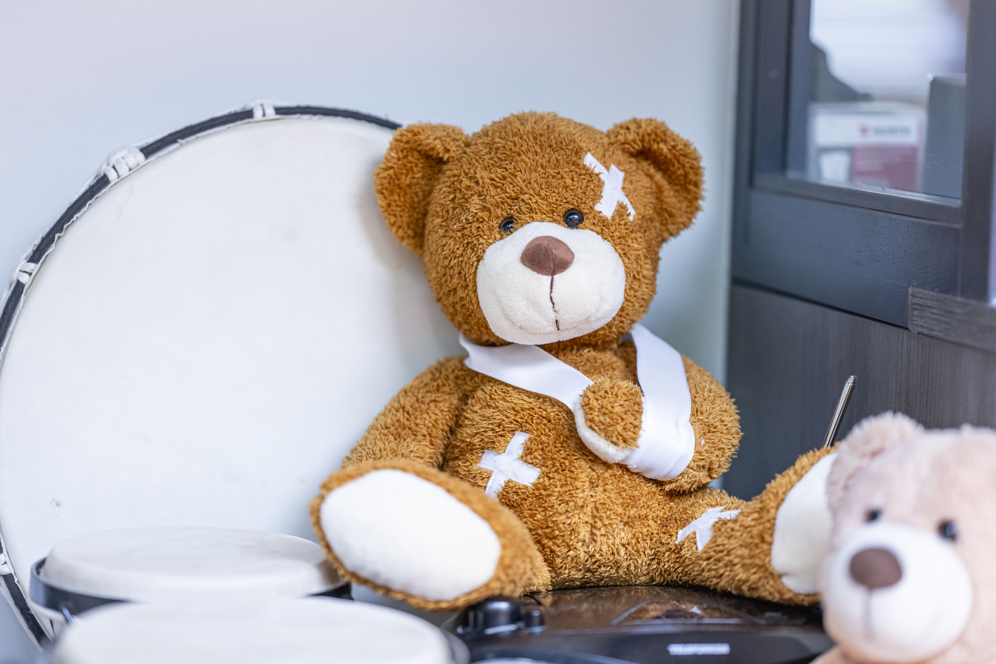 Ein Teddy mit Pflastern und Armschlaufe