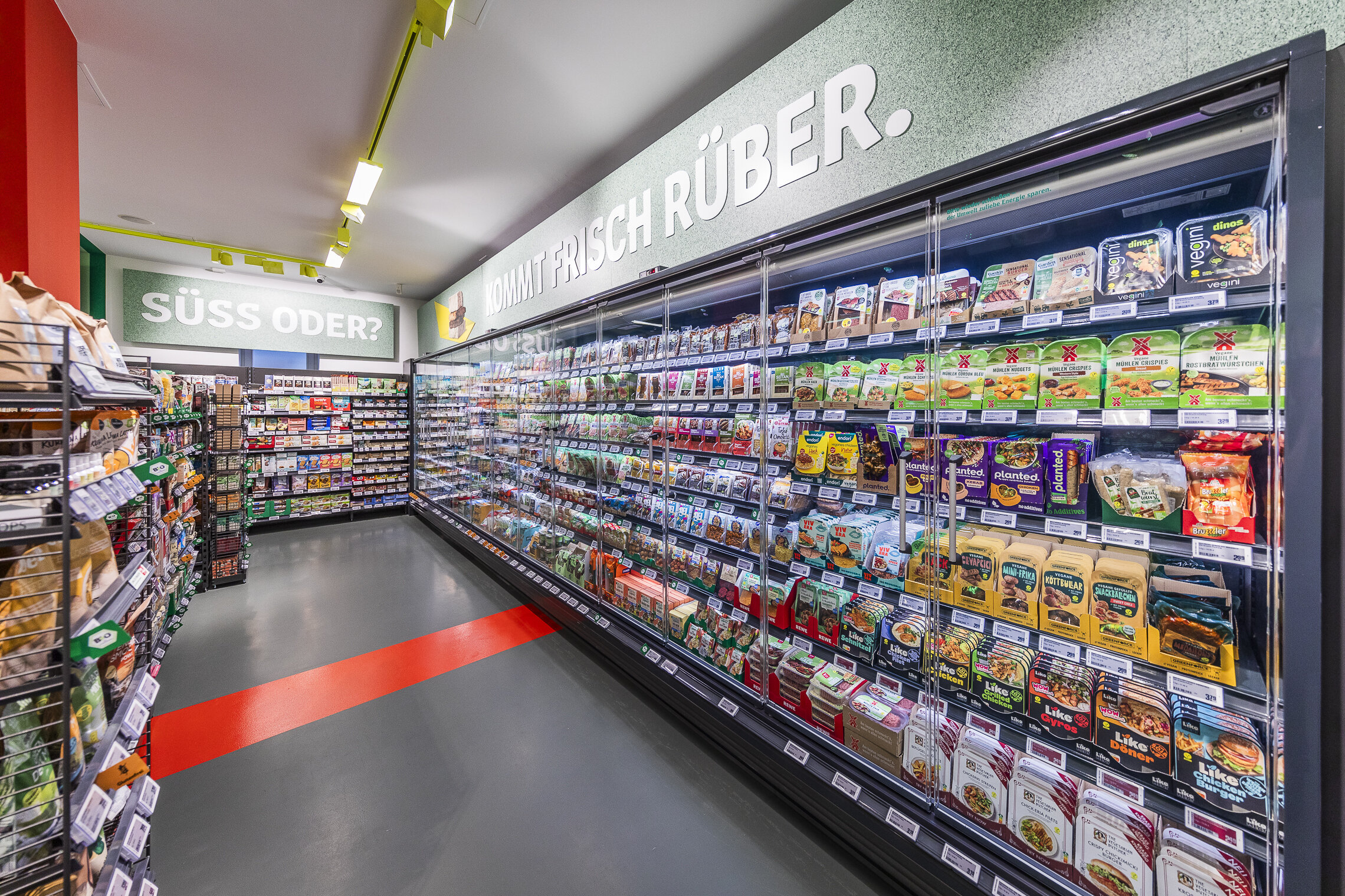 Gekühlte Produkte in Kühlschränken entlang der Wände im pflanzlichen Rewe-Markt