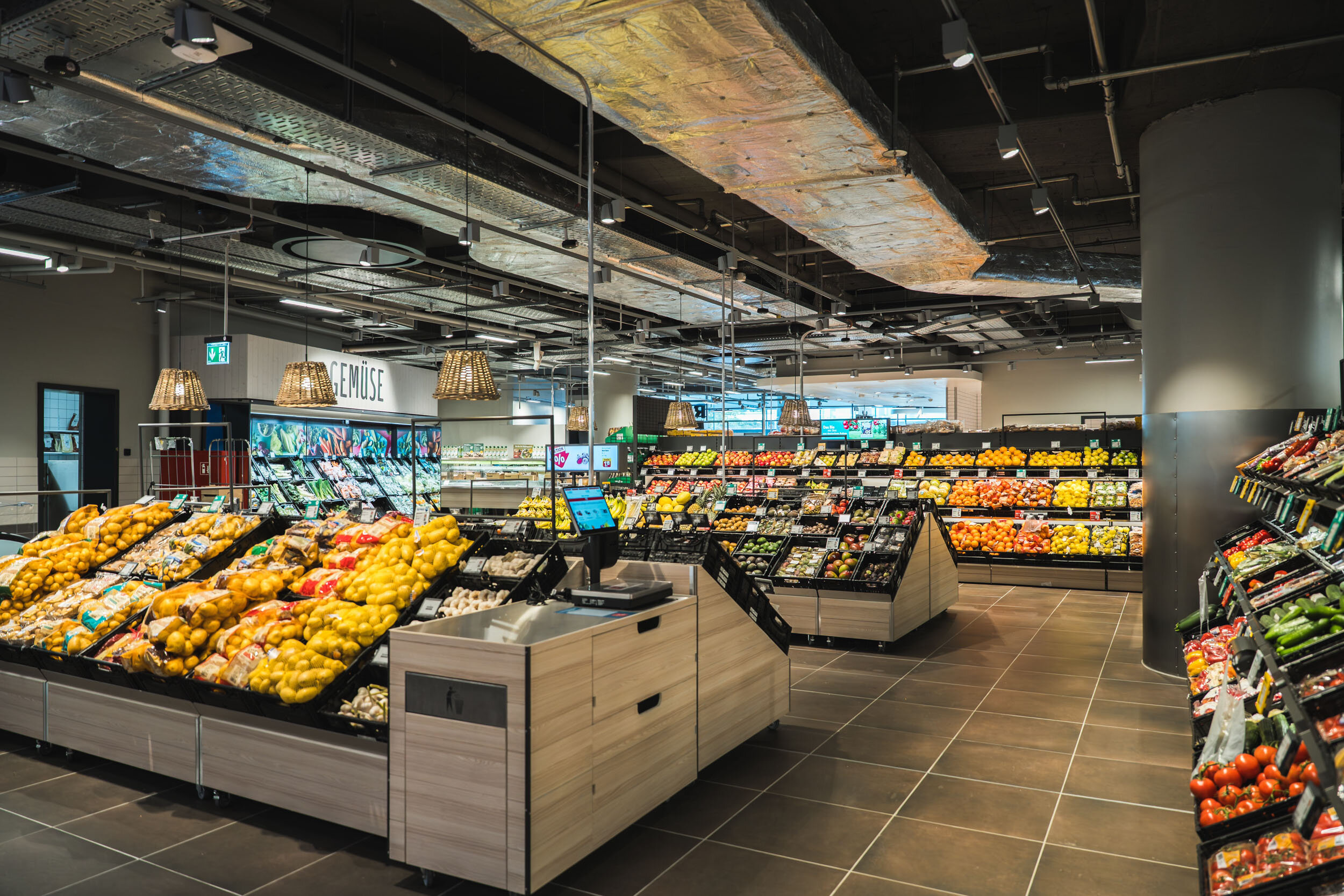 Sicht auf die Obst- und Gemüseabteilung des REWE-Supermarkts