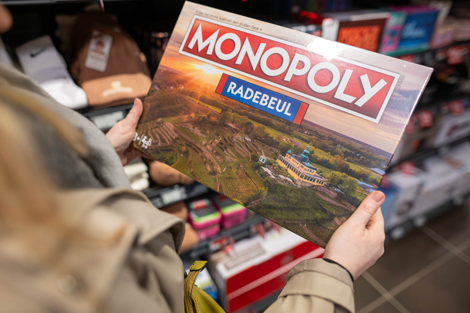 Ein Mensch hält eine Packung des Spiels Monopoly Edition Radebeul in den Händen.