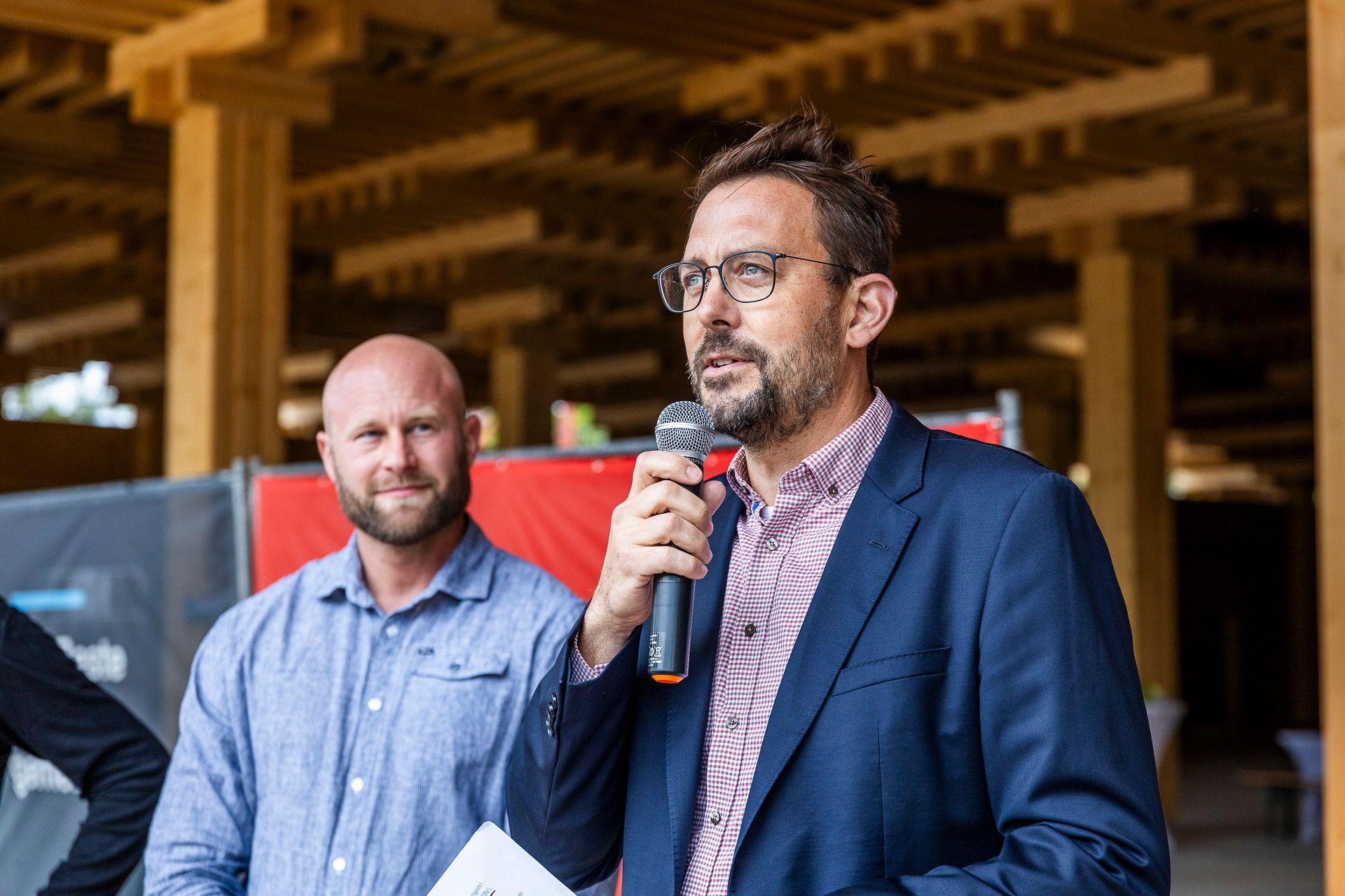 Florian Nain hält eine Rede. Im Hintergrund steht der zukünftige Kaufmann Felix Thomas.