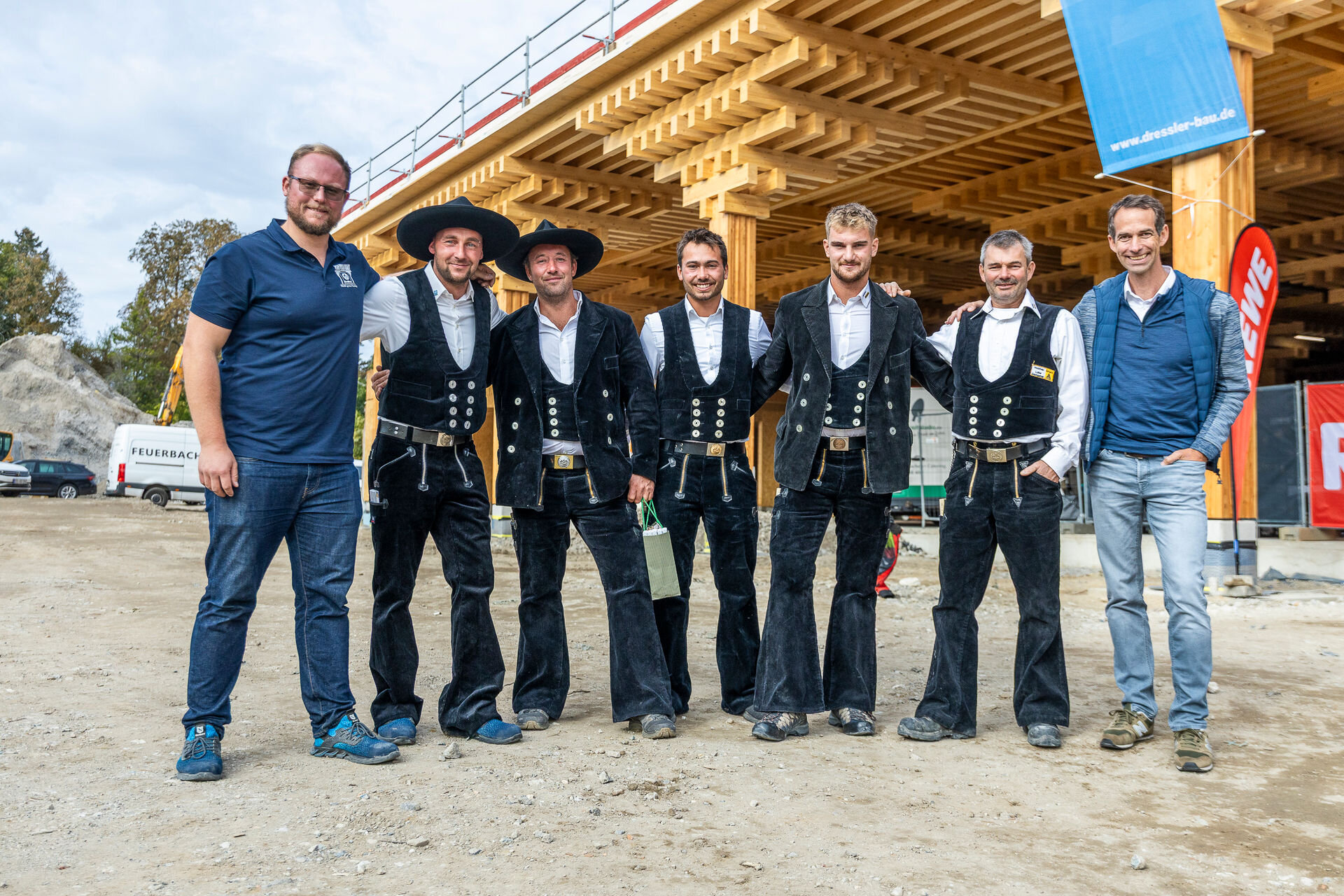 Zimmermänner stehen in Kluft vor einem Gebäude, das sich im Bau befindet.