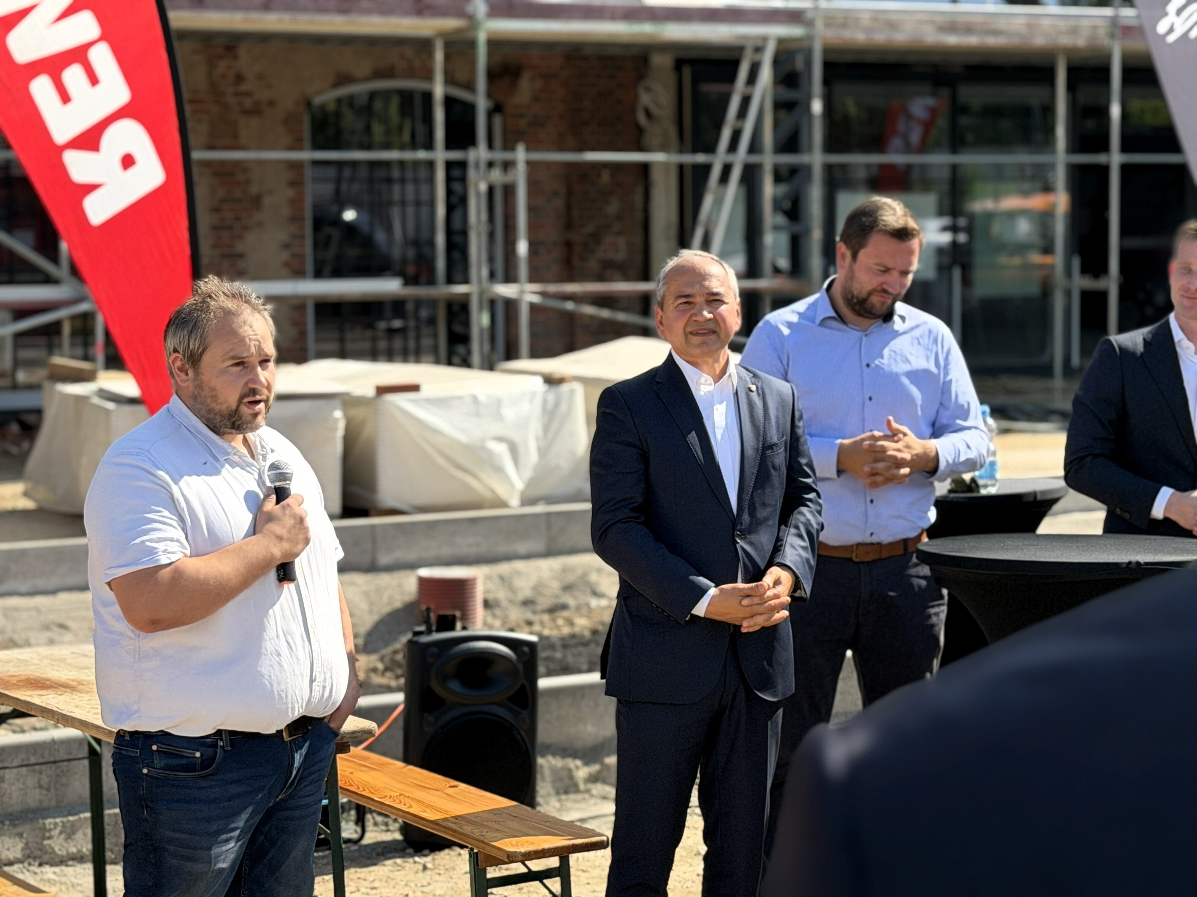 REWE-Kaufmann Benjamin Geschwill bei einer Rede mit Görlitzer OB und REWE-Vertreter:innen rechts daneben
