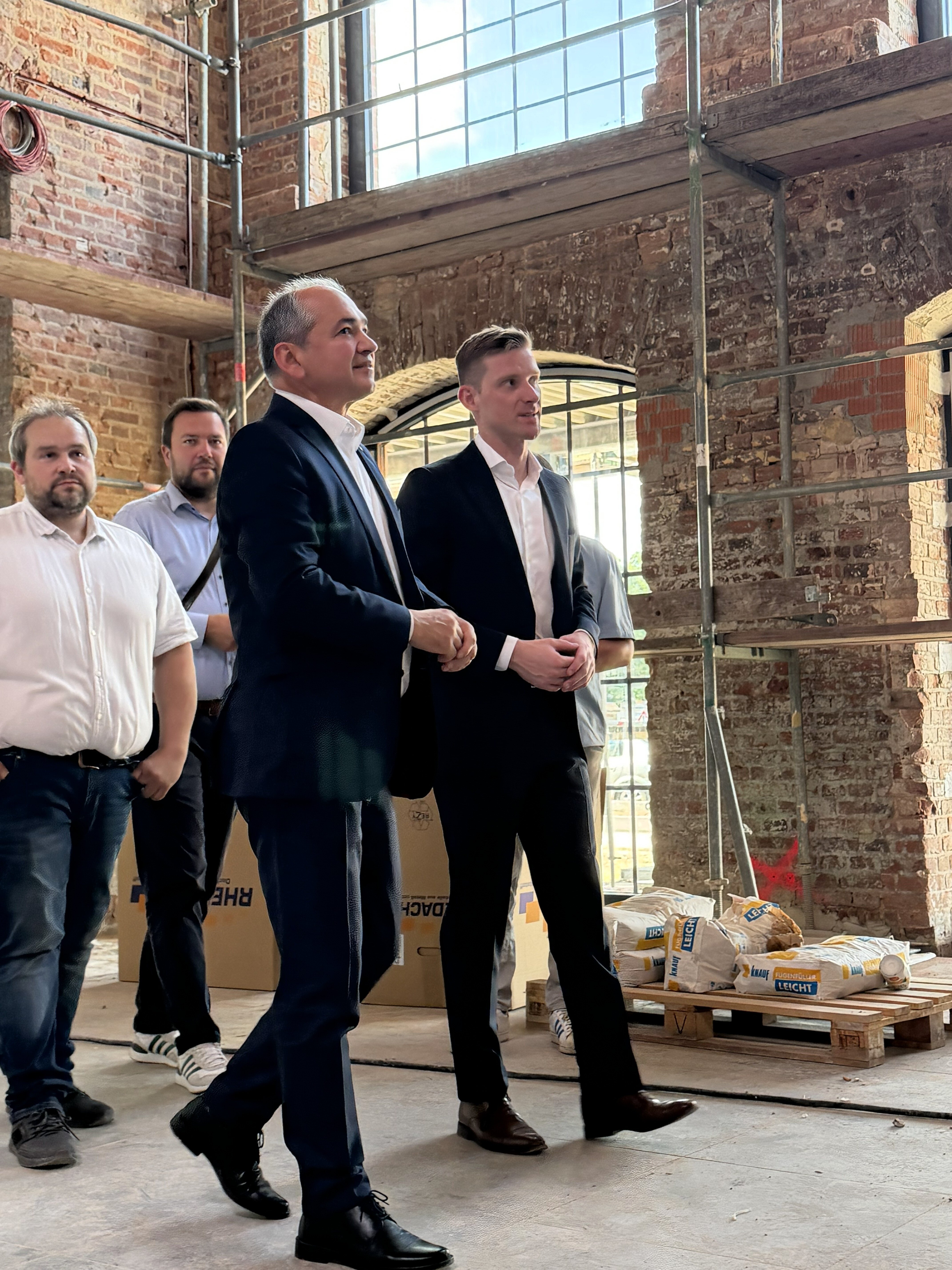 Görlitzer Oberbürgermeister Octavian Ursu mit Vertreter:innen von REWE auf der Baustelle des REWE-Marktes in Görlitz