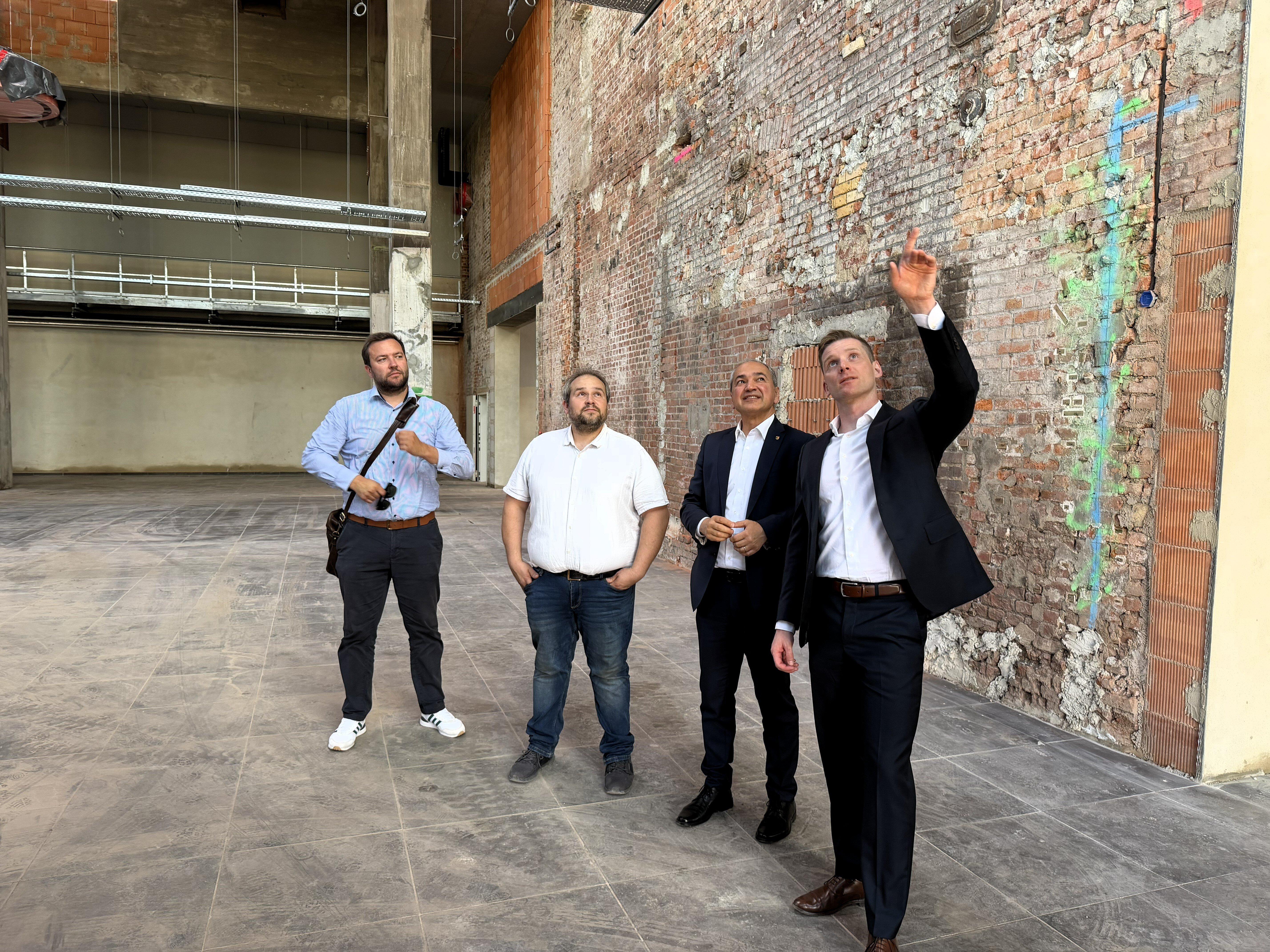 Eine Gruppe Besucher:innen auf der Baustelle des REWE-Marktes