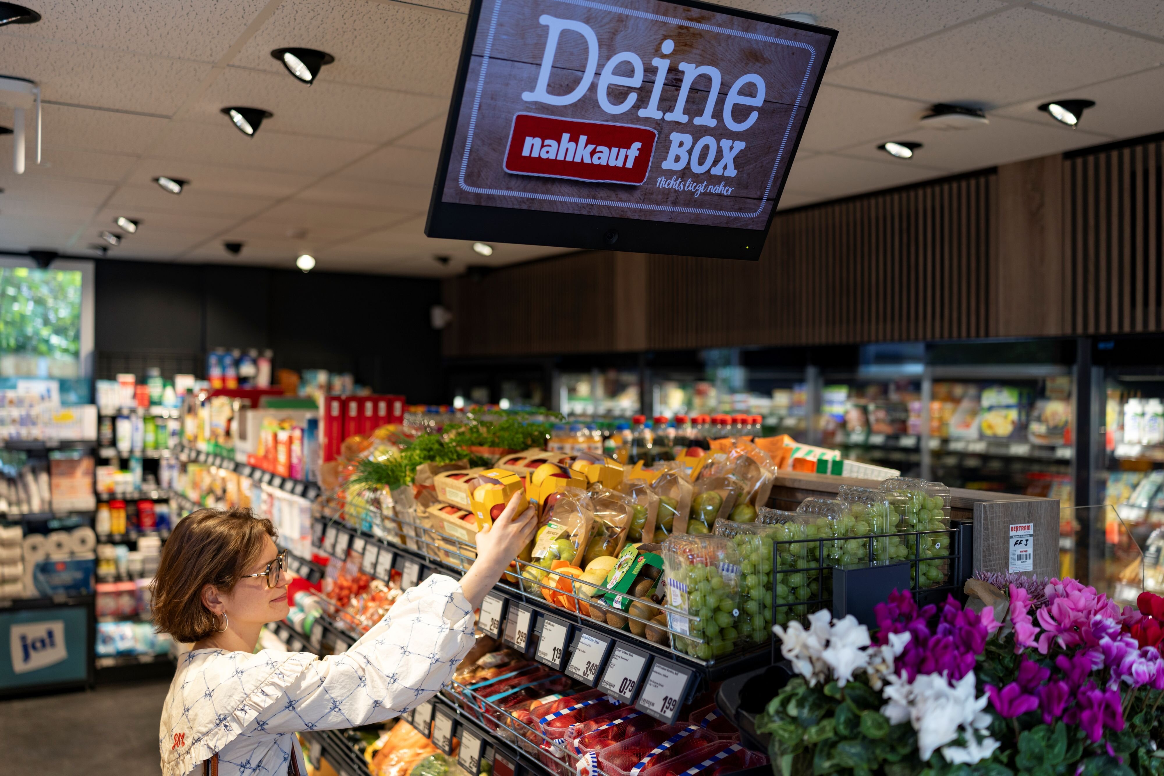 Eine Frau kauft in der Einkaufsbox ein.