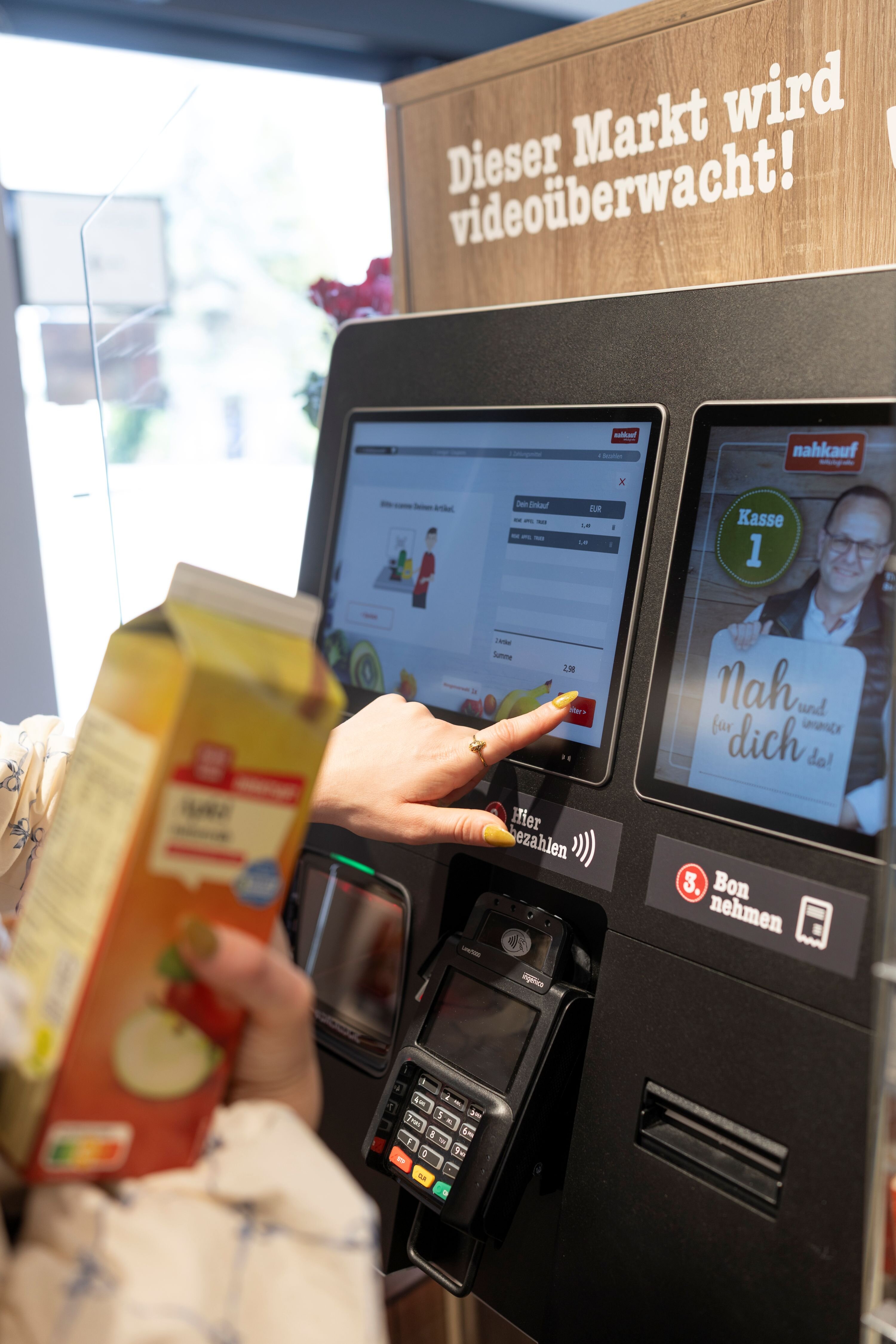 Eine Person bedient die Self-Checkout-Kasse