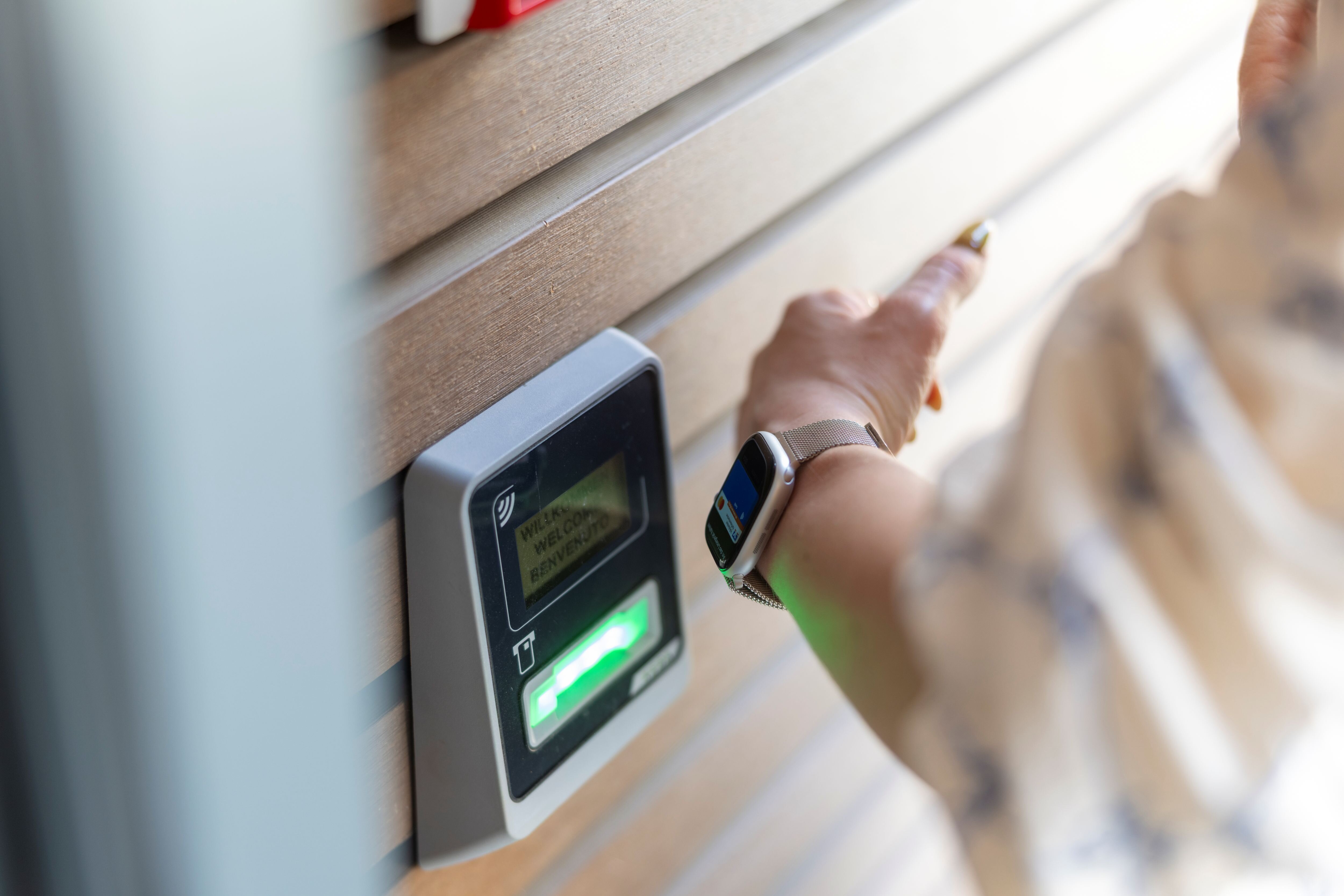 Eine Person scannt das digitale Wallet auf der Smartwatch, um die Box zu betreten