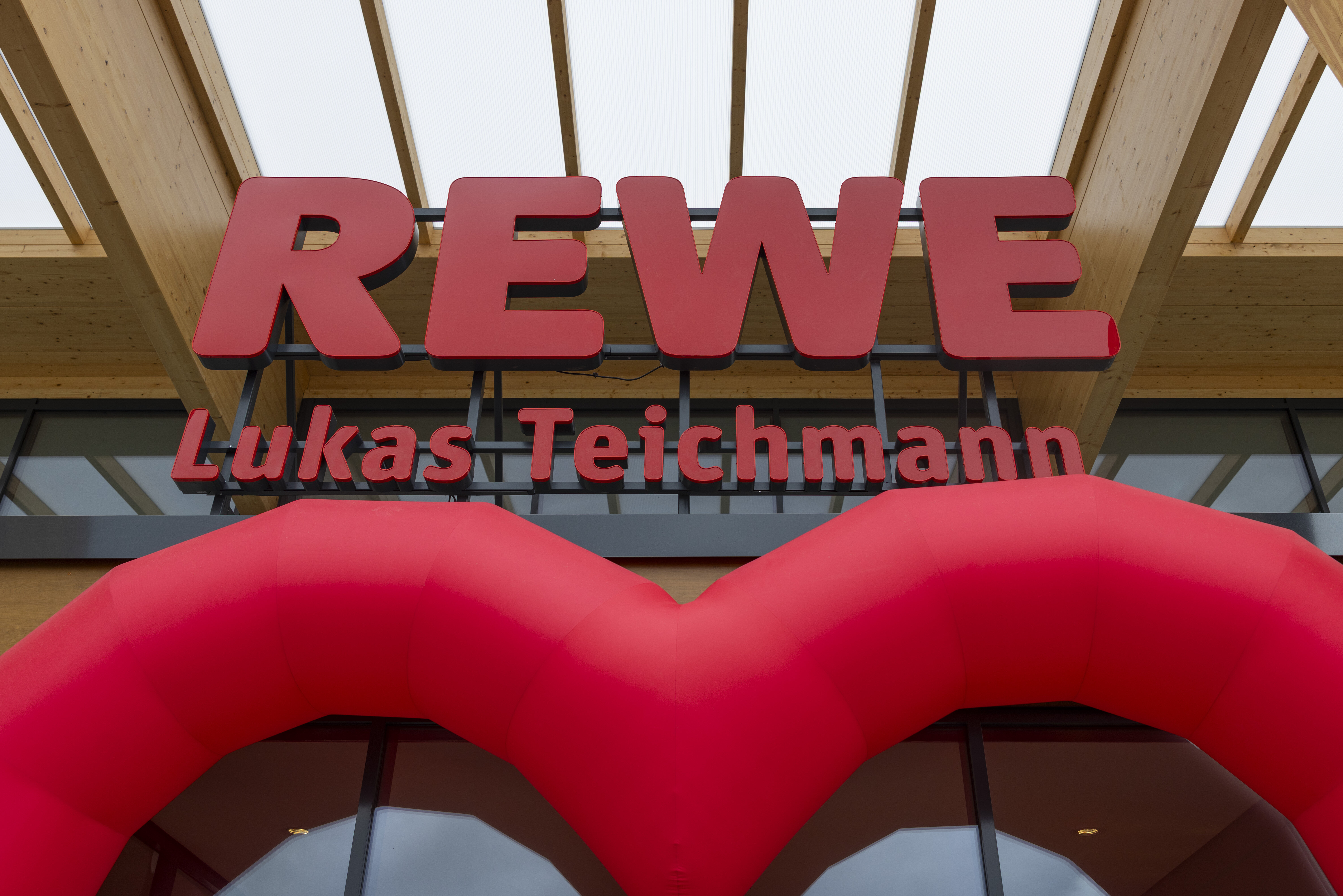 Der Eingang des neuen REWE-Marktes in Taucha mit der Firmierung des Kaufmannes Lukas Teichmann