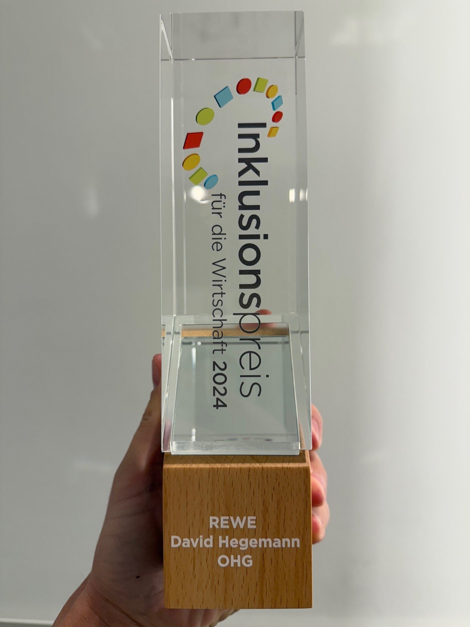 Eine Hand hÃ¤lt den Pokal zum Inklusionspreis