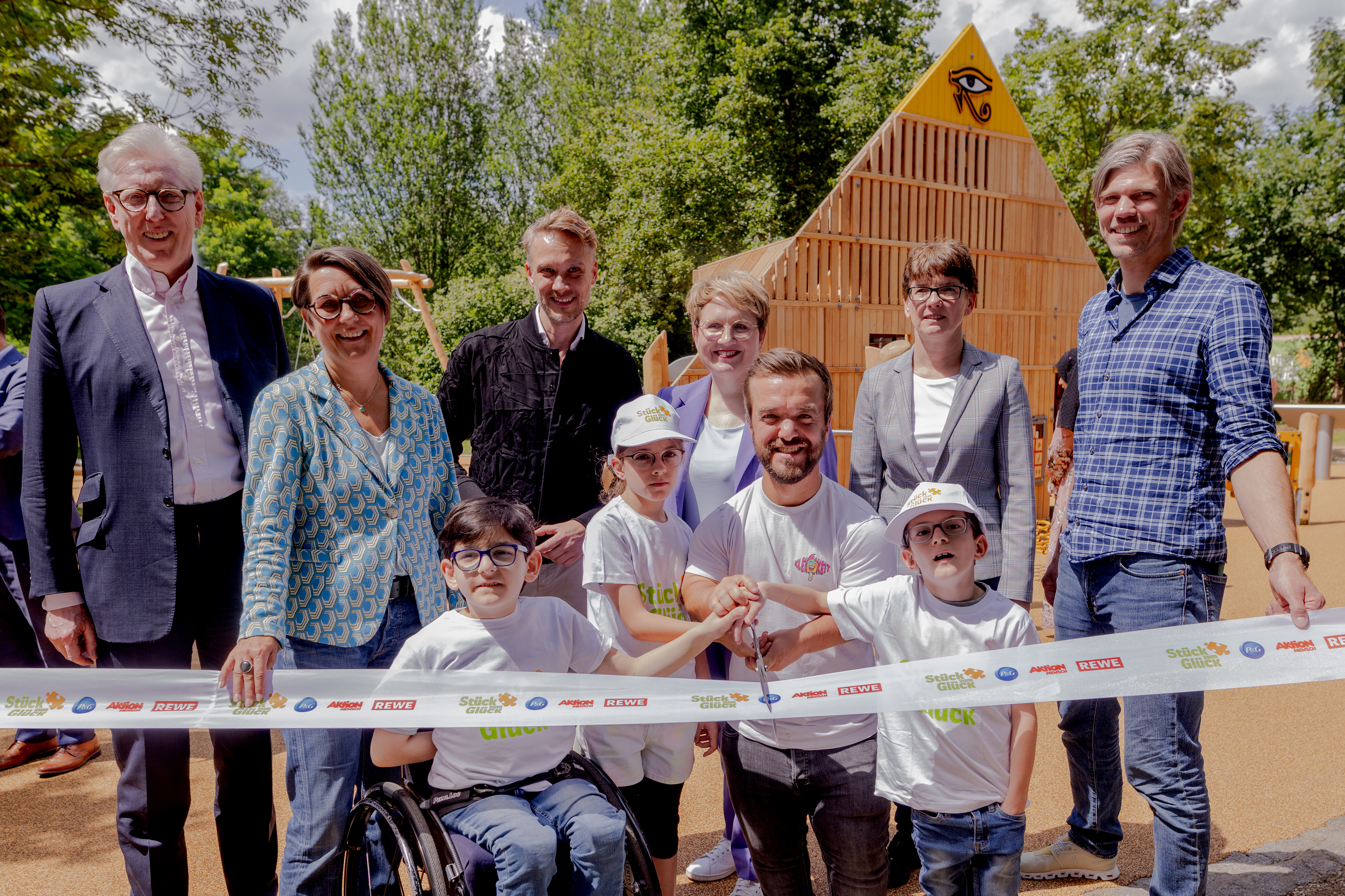 Mehrere Menschen beim Durchschneiden des ErÃ¶ffnungsbandes